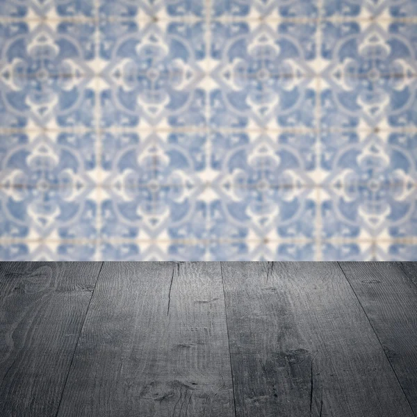 Wood table top and blur vintage ceramic tile pattern wall — Stock Photo, Image