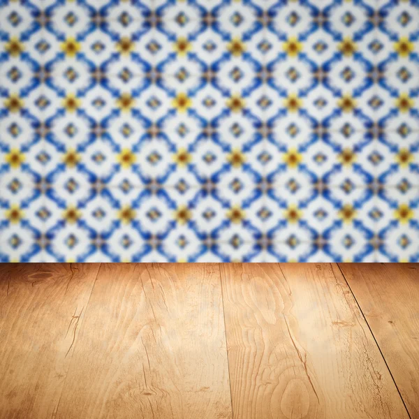 Wood table top and blur vintage ceramic tile pattern wall — Stock Photo, Image