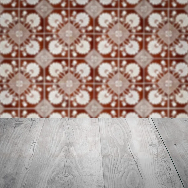 Wood table top and blur vintage ceramic tile pattern wall — Stock Photo, Image