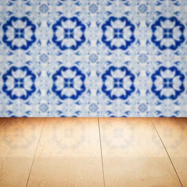 Wood table top and blur vintage ceramic tile pattern wall — Stock Photo, Image