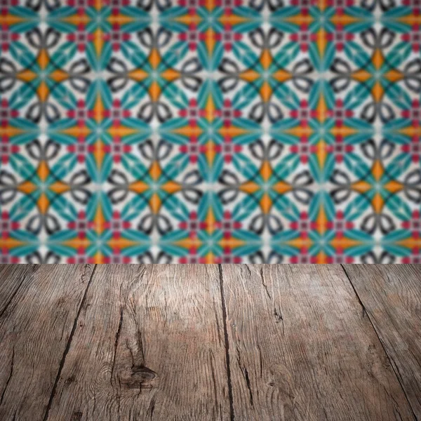 Wood table top and blur vintage ceramic tile pattern wall — Stock Photo, Image