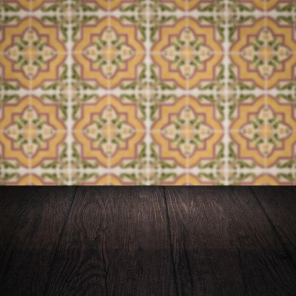 Wood table top and blur vintage ceramic tile pattern wall — Stock Photo, Image