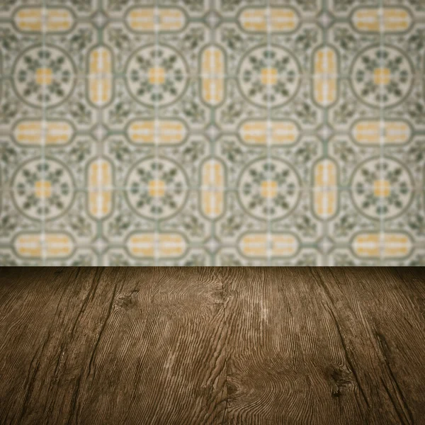 Wood table top and blur vintage ceramic tile pattern wall — Stock Photo, Image