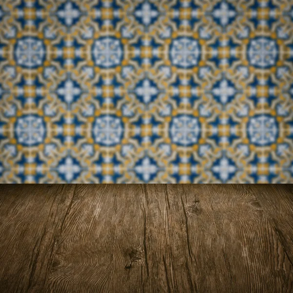 Wood table top and blur vintage ceramic tile pattern wall — Stock Photo, Image