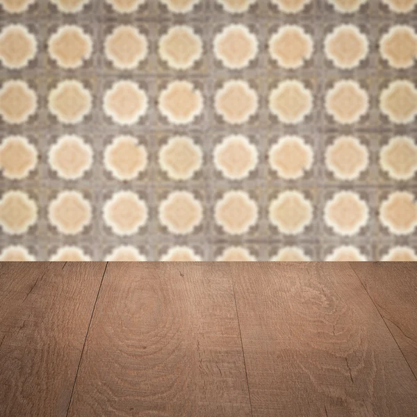 Wood table top and blur vintage ceramic tile pattern wall — Stock Photo, Image