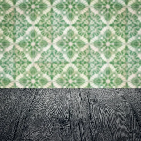 Wood table top and blur vintage ceramic tile pattern wall — Stock Photo, Image