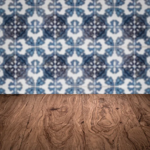 Wood table top and blur vintage ceramic tile pattern wall — Stock Photo, Image