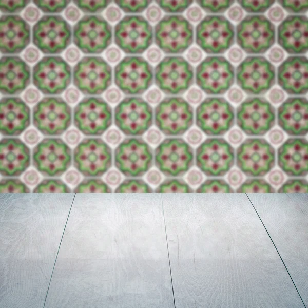 Wood table top and blur vintage ceramic tile pattern wall — Stock Photo, Image