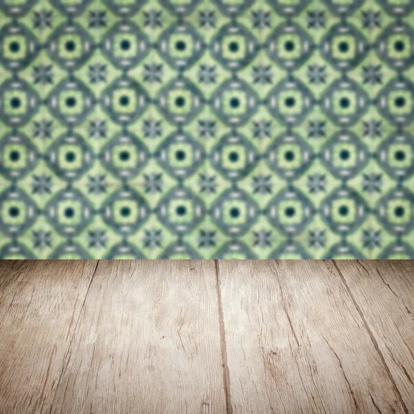 Wood table top and blur vintage ceramic tile pattern wall — Stock Photo, Image