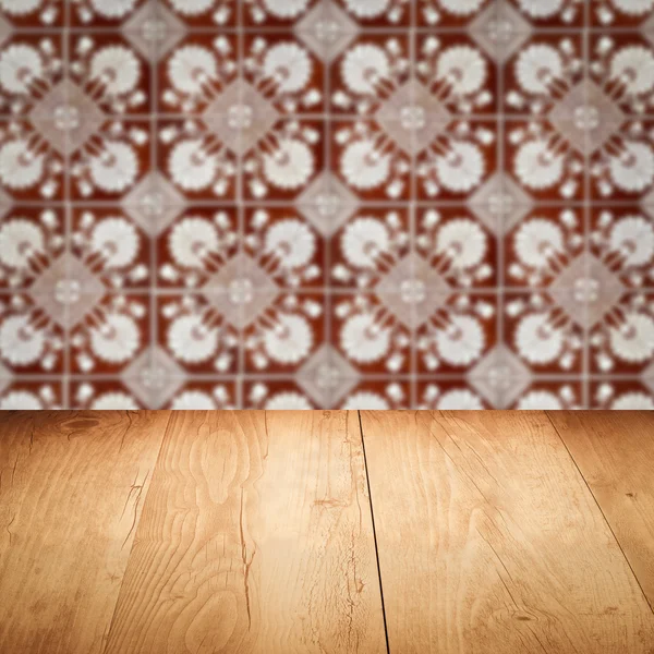 Wood table top and blur vintage ceramic tile pattern wall — Stock Photo, Image