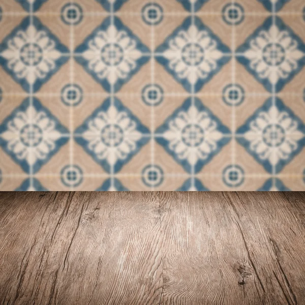 Wood table top and blur vintage ceramic tile pattern wall — Stock Photo, Image