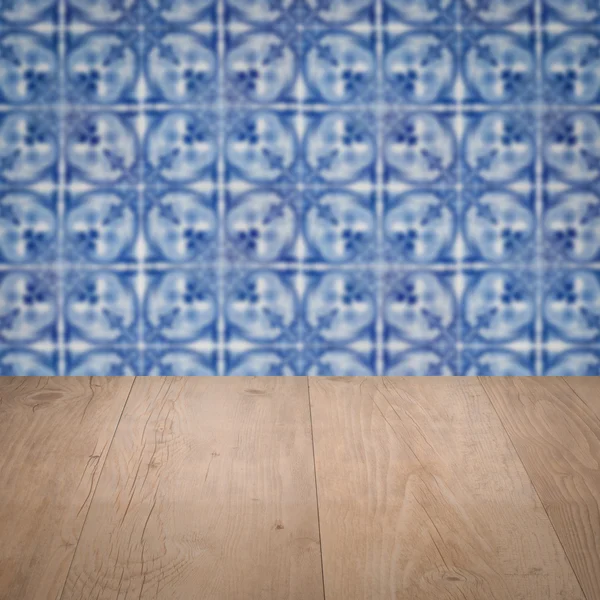 Wood table top and blur vintage ceramic tile pattern wall — Stock Photo, Image