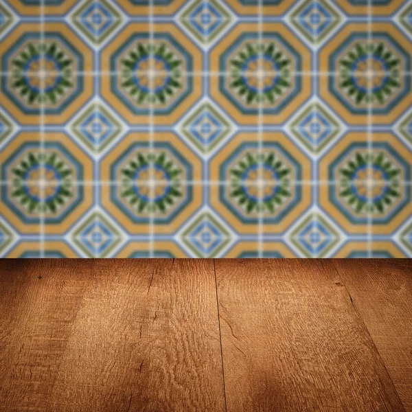 Wood table top and blur vintage ceramic tile pattern wall — Stock Photo, Image