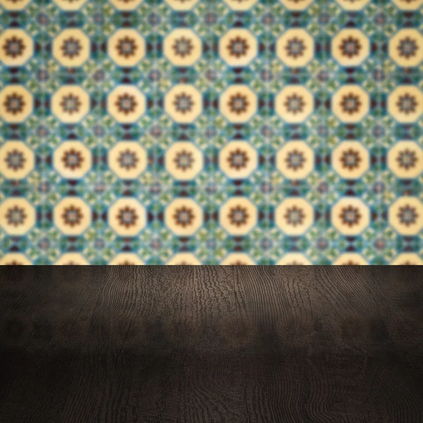 Wood table top and blur vintage ceramic tile pattern wall — Stock Photo, Image