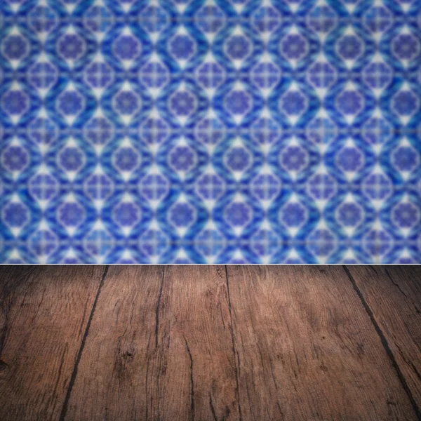 Wood table top and blur vintage ceramic tile pattern wall — Stock Photo, Image