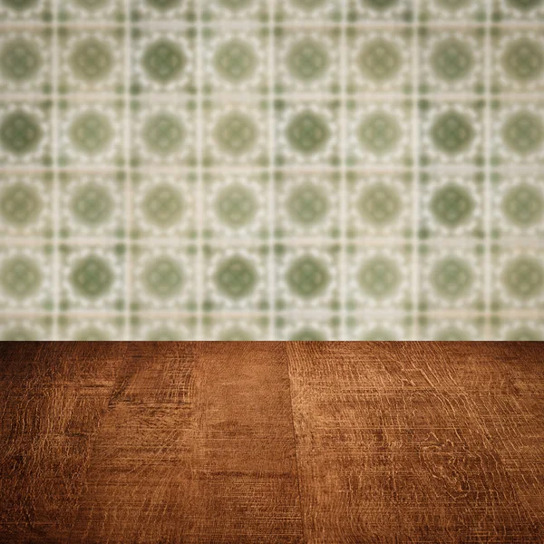 Wood table top and blur vintage ceramic tile pattern wall — Stock Photo, Image