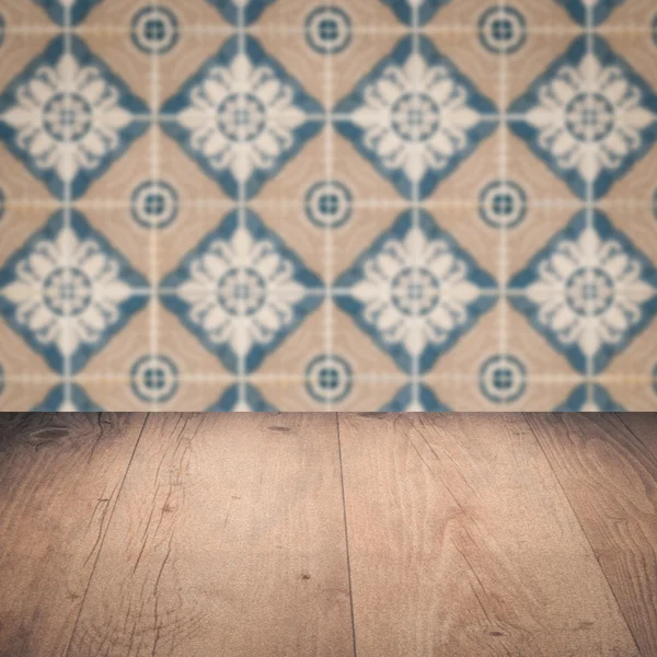 Wood table top and blur vintage ceramic tile pattern wall — Stock Photo, Image