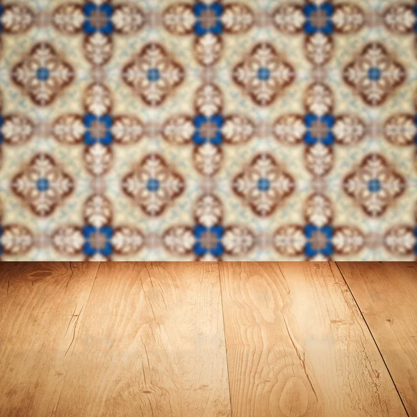 Wood table top and blur vintage ceramic tile pattern wall — Stock Photo, Image