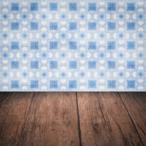 Wood table top and blur vintage ceramic tile pattern wall — Stock Photo, Image