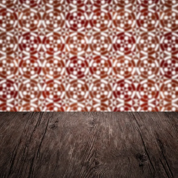 Wood table top and blur vintage ceramic tile pattern wall Stock Photo