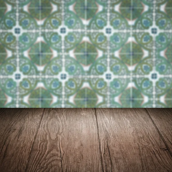 Wood table top and blur vintage ceramic tile pattern wall — Stock Photo, Image