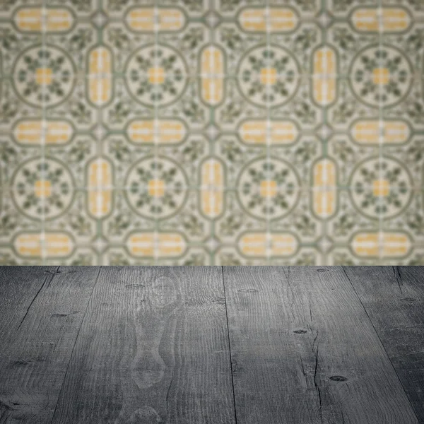 Wood table top and blur vintage ceramic tile pattern wall — Stock Photo, Image