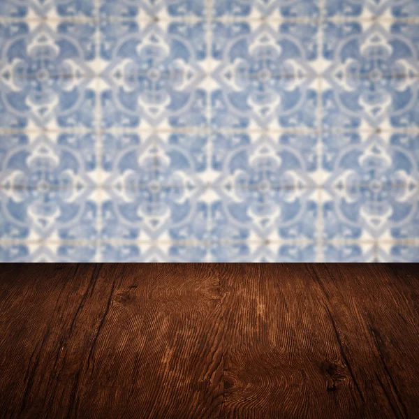 Wood table top and blur vintage ceramic tile pattern wall — Stock Photo, Image