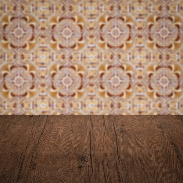 Wood table top and blur vintage ceramic tile pattern wall — Stock Photo, Image