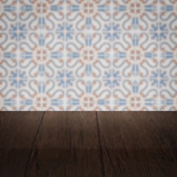 Wood table top and blur vintage ceramic tile pattern wall — Stock Photo, Image