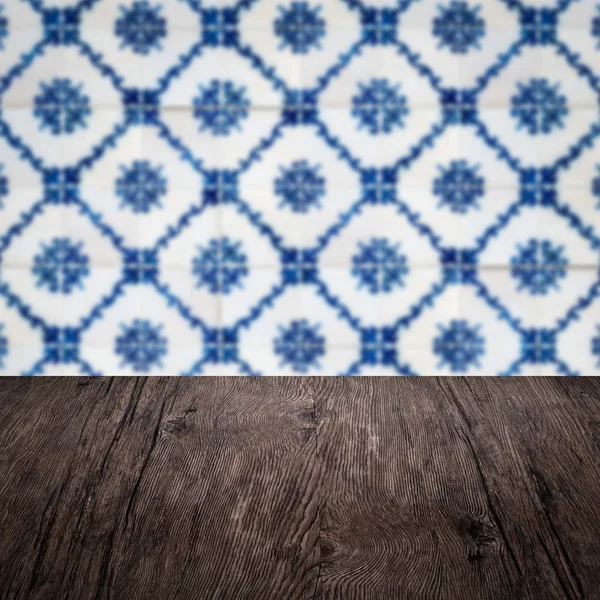 Wood table top and blur vintage ceramic tile pattern wall — Stock Photo, Image