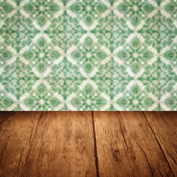 Wood table top and blur vintage ceramic tile pattern wall — Stock Photo, Image