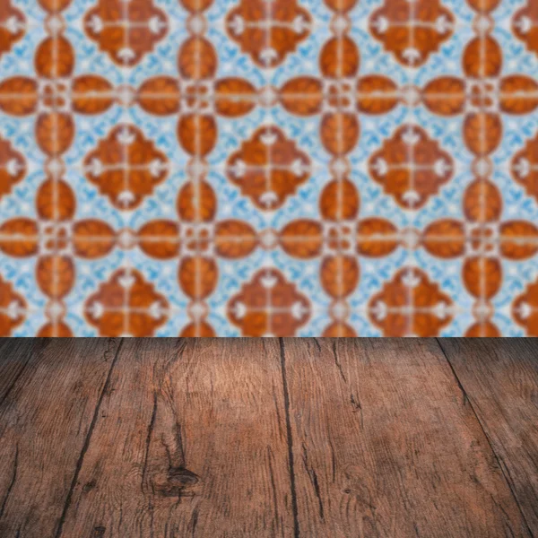 Wood table top and blur vintage ceramic tile pattern wall — Stock Photo, Image