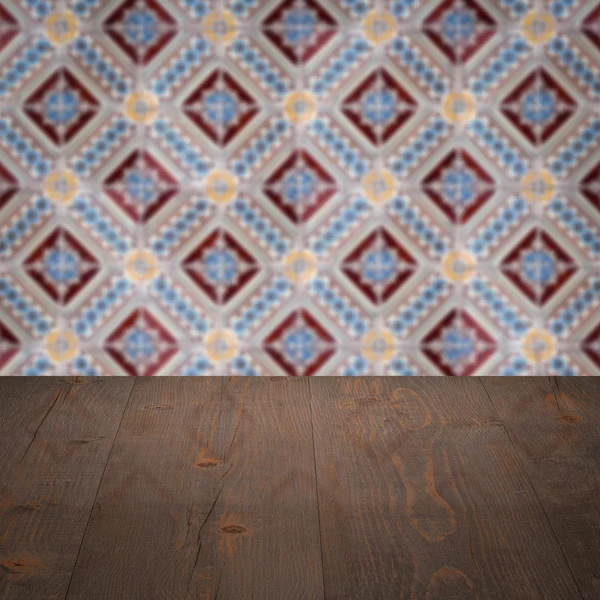 Wood table top and blur vintage ceramic tile pattern wall — Stock Photo, Image