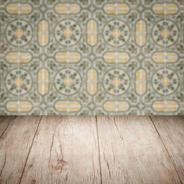 Wood table top and blur vintage ceramic tile pattern wall — Stock Photo, Image