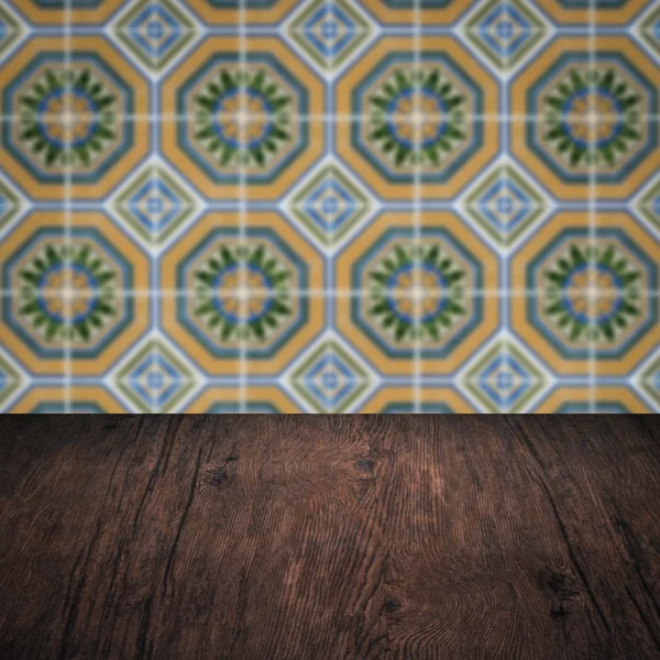 Wood table top and blur vintage ceramic tile pattern wall — Stock Photo, Image