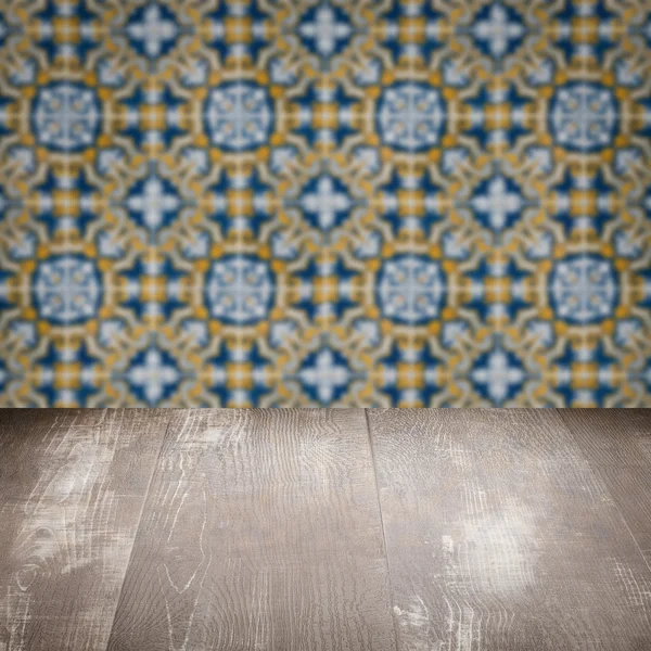 Wood table top and blur vintage ceramic tile pattern wall — Stock Photo, Image