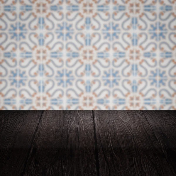 Wood table top and blur vintage ceramic tile pattern wall — Stock Photo, Image