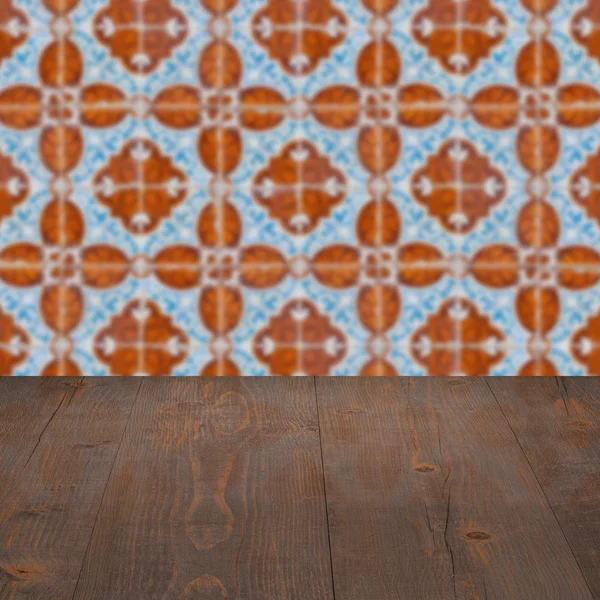 Wood table top and blur vintage ceramic tile pattern wall — Stock Photo, Image