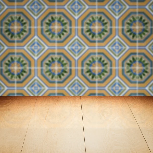 Wood table top and blur vintage ceramic tile pattern wall — Stock Photo, Image