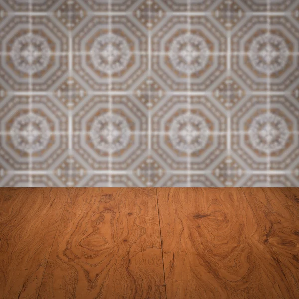 Wood table top and blur vintage ceramic tile pattern wall — Stock Photo, Image