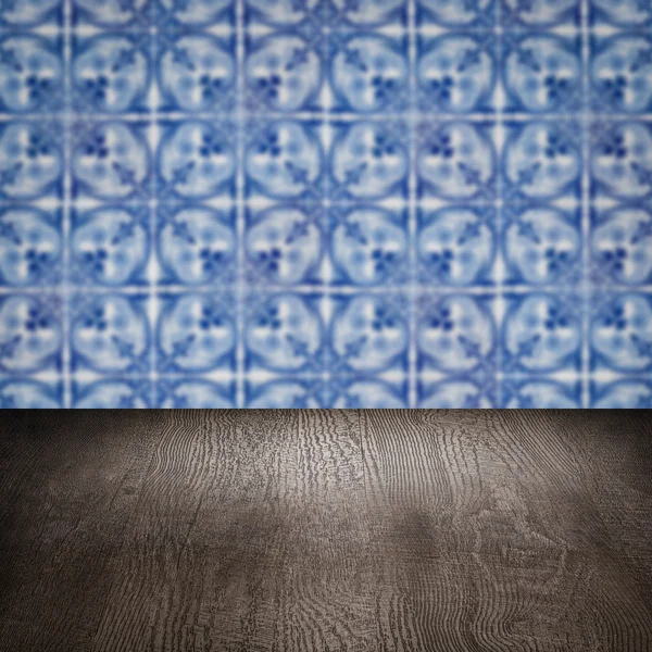 Wood table top and blur vintage ceramic tile pattern wall — Stock Photo, Image