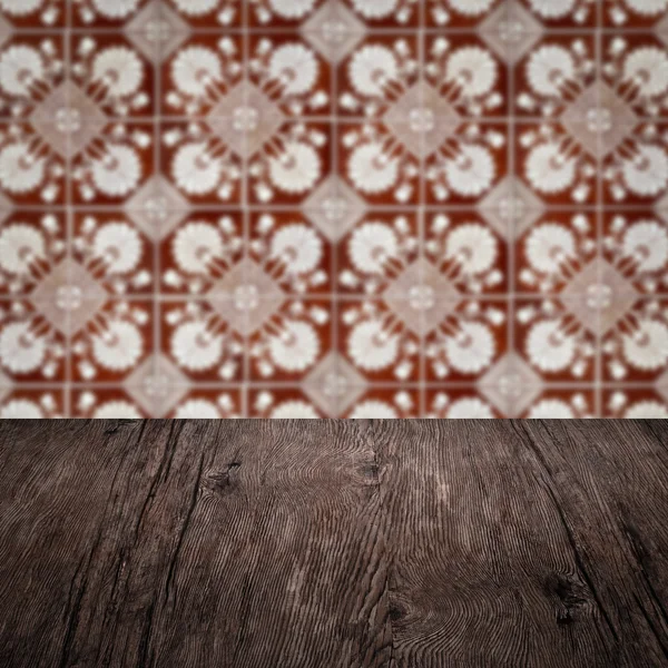 Wood table top and blur vintage ceramic tile pattern wall — Stock Photo, Image