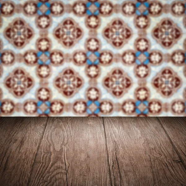 Wood table top and blur vintage ceramic tile pattern wall — Stock Photo, Image