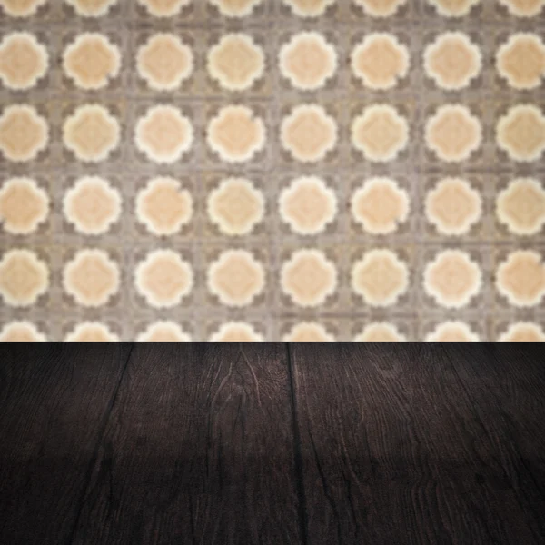 Wood table top and blur vintage ceramic tile pattern wall Stock Image