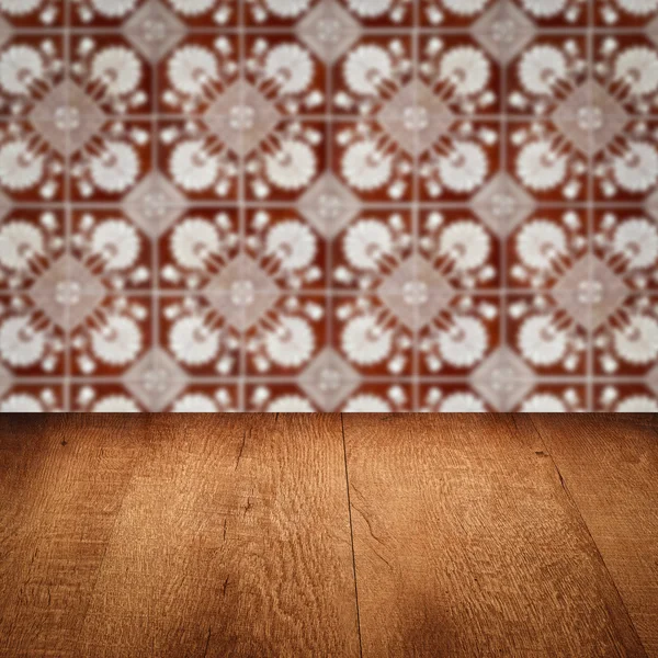 Wood table top and blur vintage ceramic tile pattern wall — Stock Photo, Image