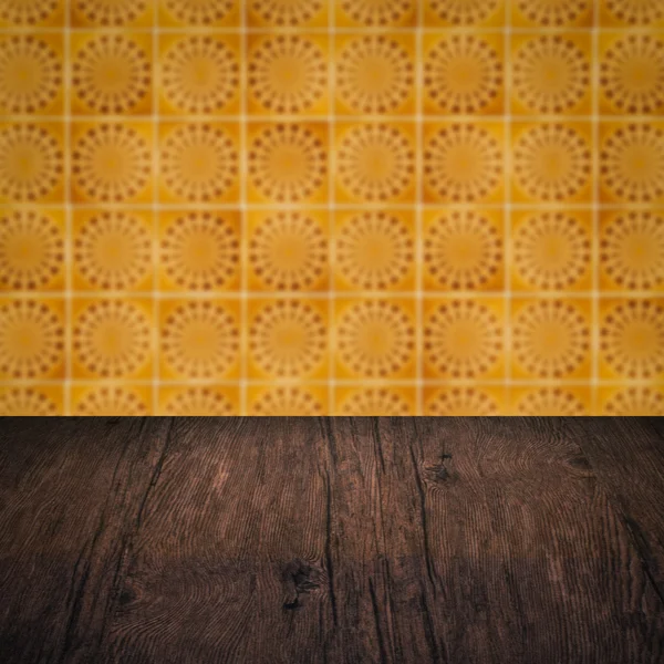 Wood table top and blur vintage ceramic tile pattern wall — Stock Photo, Image