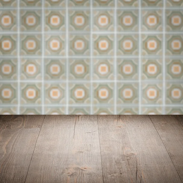 Wood table top and blur vintage ceramic tile pattern wall — Stock Photo, Image