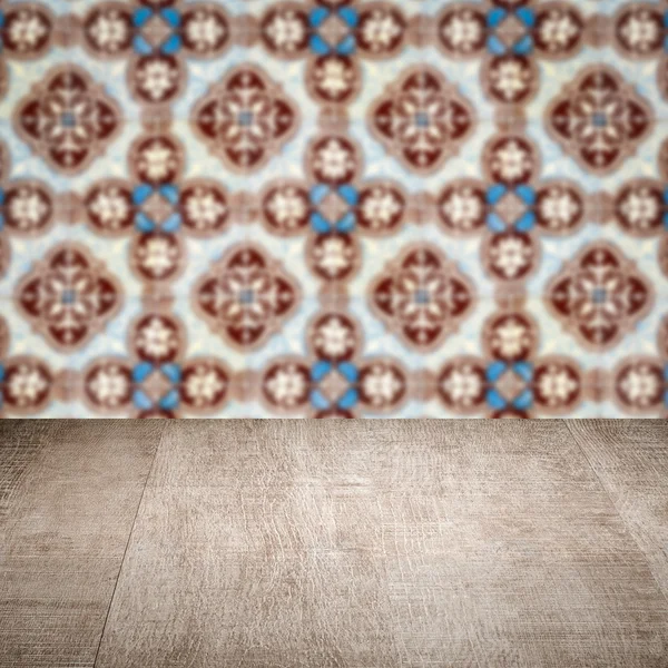 Wood table top and blur vintage ceramic tile pattern wall — Stock Photo, Image