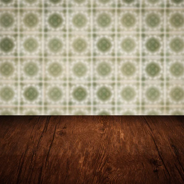 Wood table top and blur vintage ceramic tile pattern wall — Stock Photo, Image