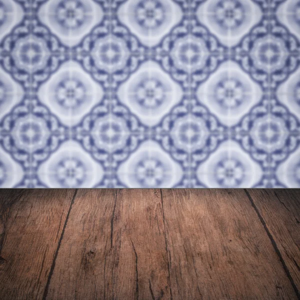 Wood table top and blur vintage ceramic tile pattern wall — Stock Photo, Image